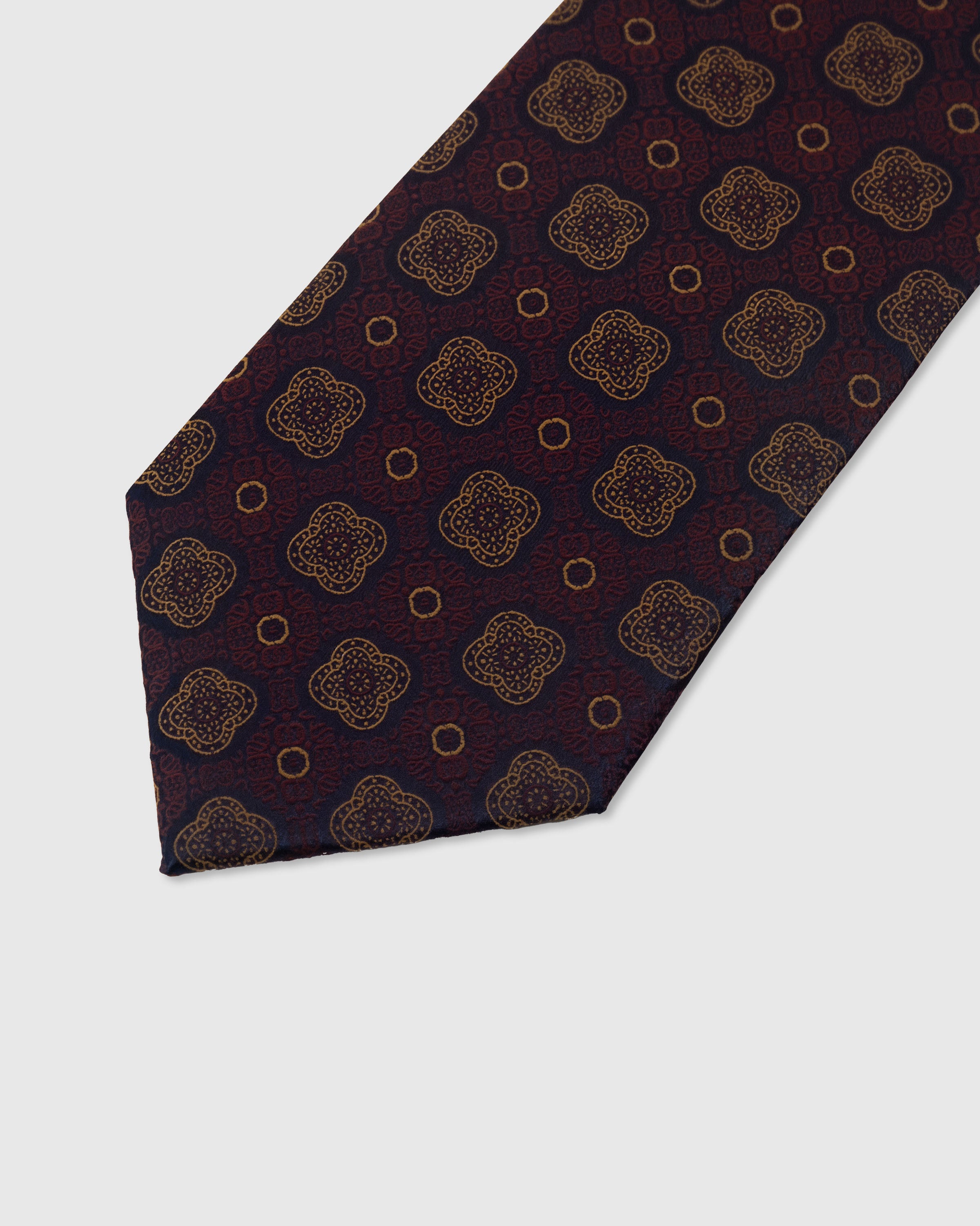 Amber quatrefoil medallion detail on claret mulberry silk tie showing raised hand-embroidered thread by STICKYZOO