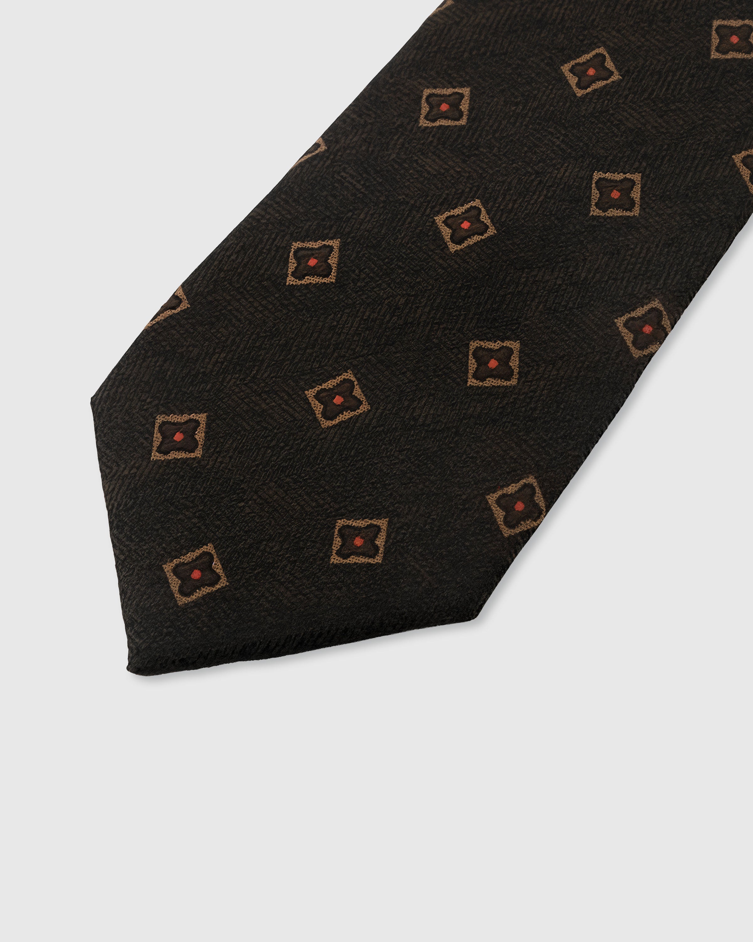 STICKYZOO ESPRESSO DIAMOND TIE — hand-embroidered detail showing gold-framed diamond motifs with crimson centers, stitched not printed