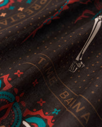 Close-up of the hand-illustrated skeleton dancer in red dress printed on the charcoal silk field
```