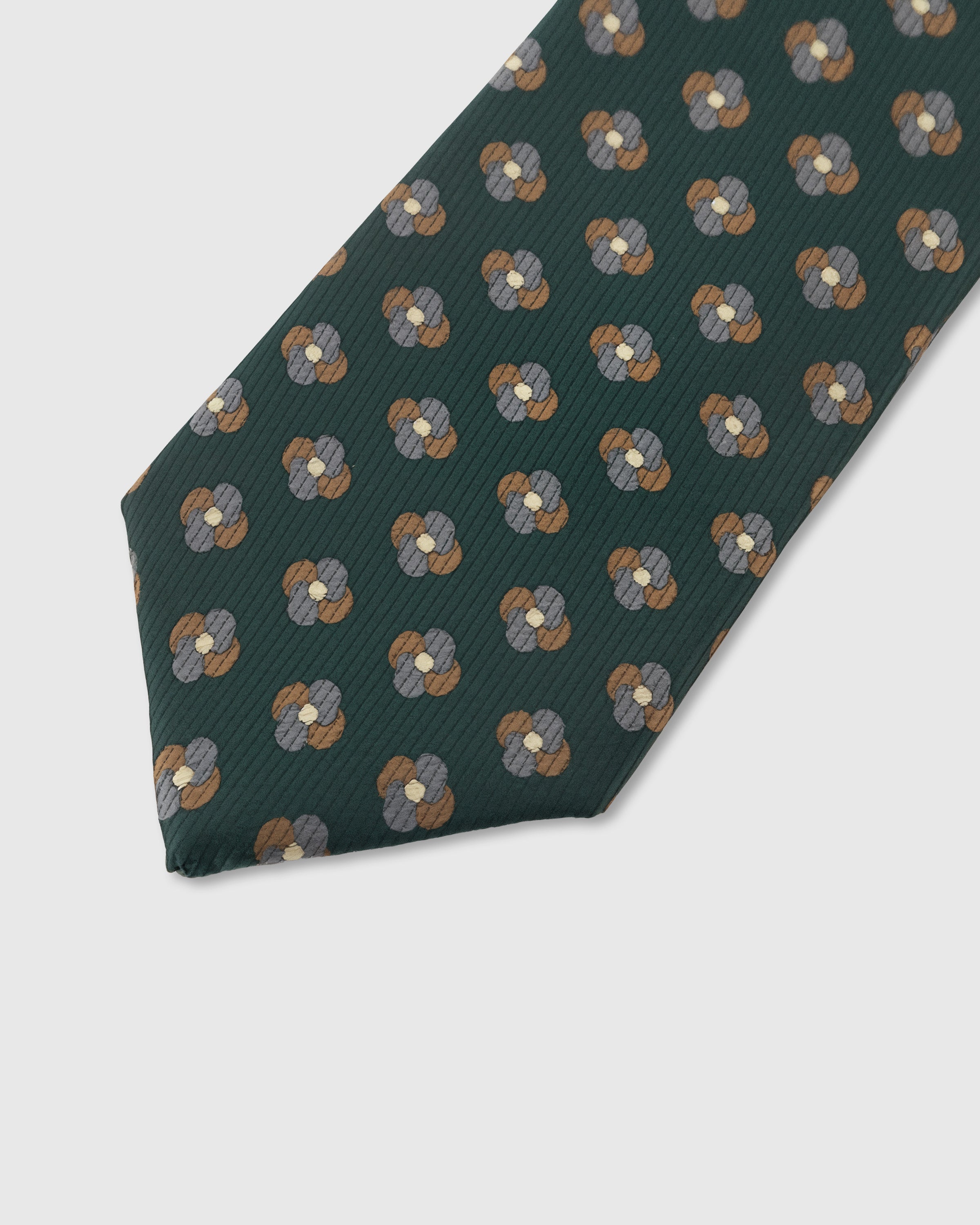 Bronze clover motif detail on pine mulberry silk tie showing raised hand-embroidered petals by STICKYZOO