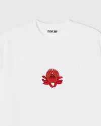 Hand-beaded crab on the white Crab T-Shirt showing red-orange glass beads and crystal accents on 230gsm cool-touch cotton.