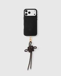 Mocha leather bow strap attached to black phone case showing full pairing