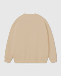 Model wearing Poodle Parade Sweatshirt in beige showing relaxed silhouette and dropped shoulders