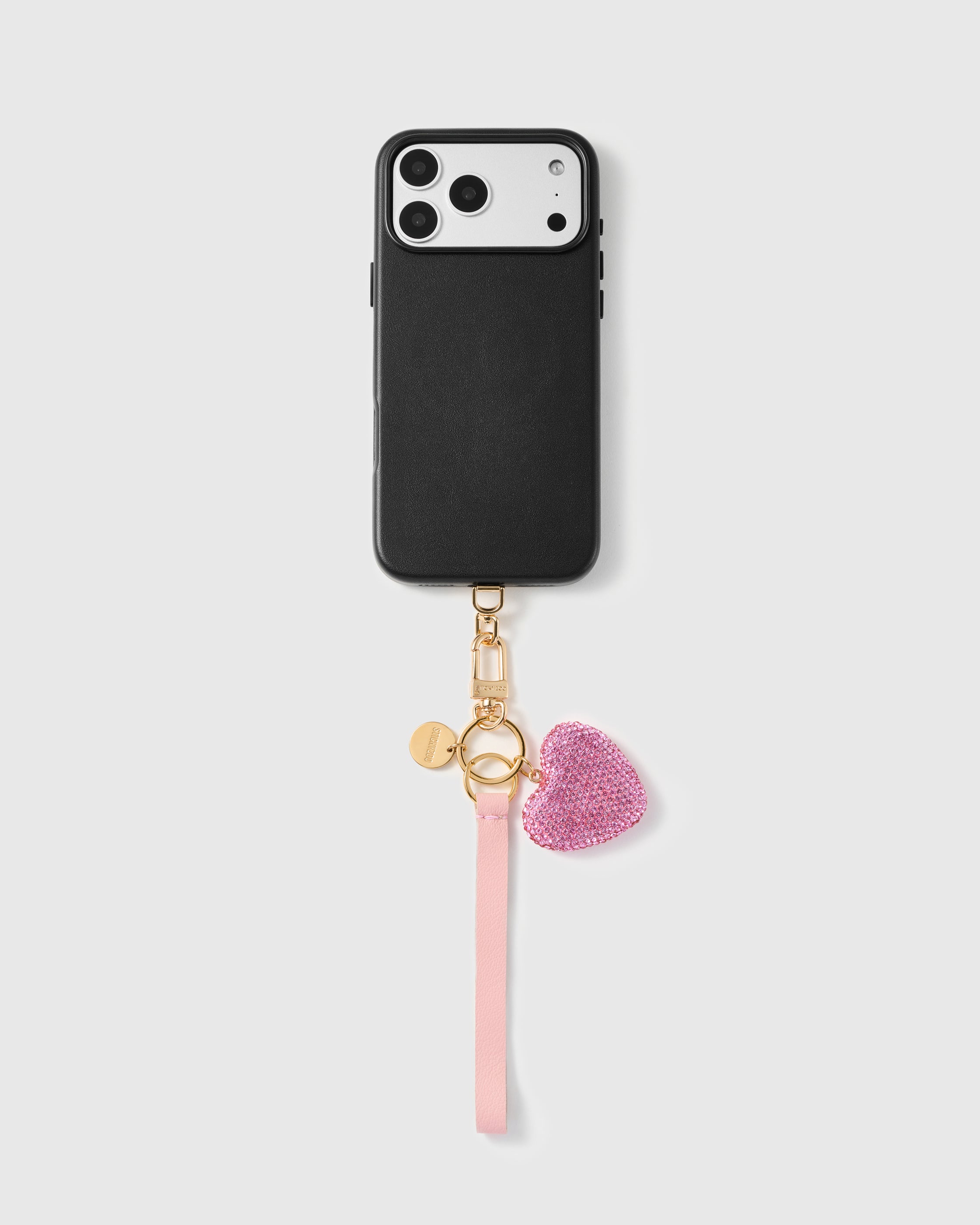 Close-up of hot pink crystal-pavé heart showing hand-set stones on gold backing