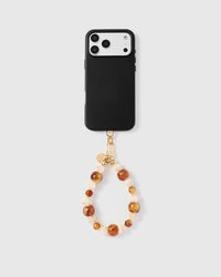 Full phone with amber marble mixed stone strap attached on grey background