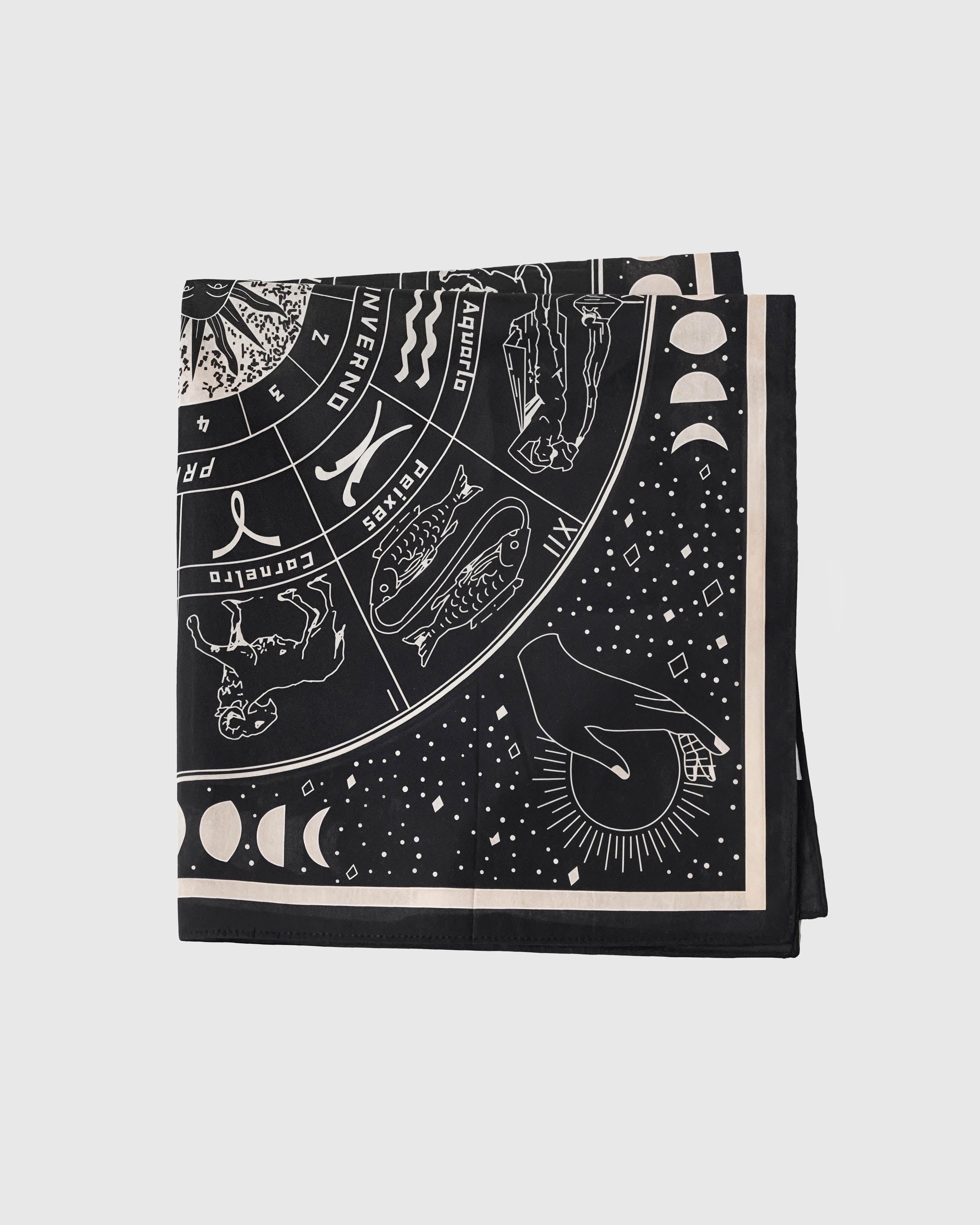 Folded zodiac silk scarf showing the printed signs and the ivory inner frame on midnight silk