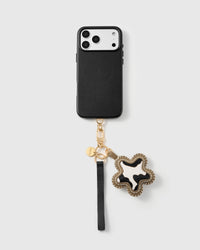 Cow star leather phone strap clipped to a black phone case, hands-free wrist strap