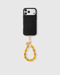 Full phone with saffron agate bead strap attached on light grey background