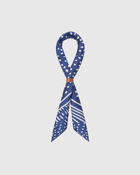 STICKYZOO stardust silk scarf looped through a leather cuff showing the larger polka-dot border