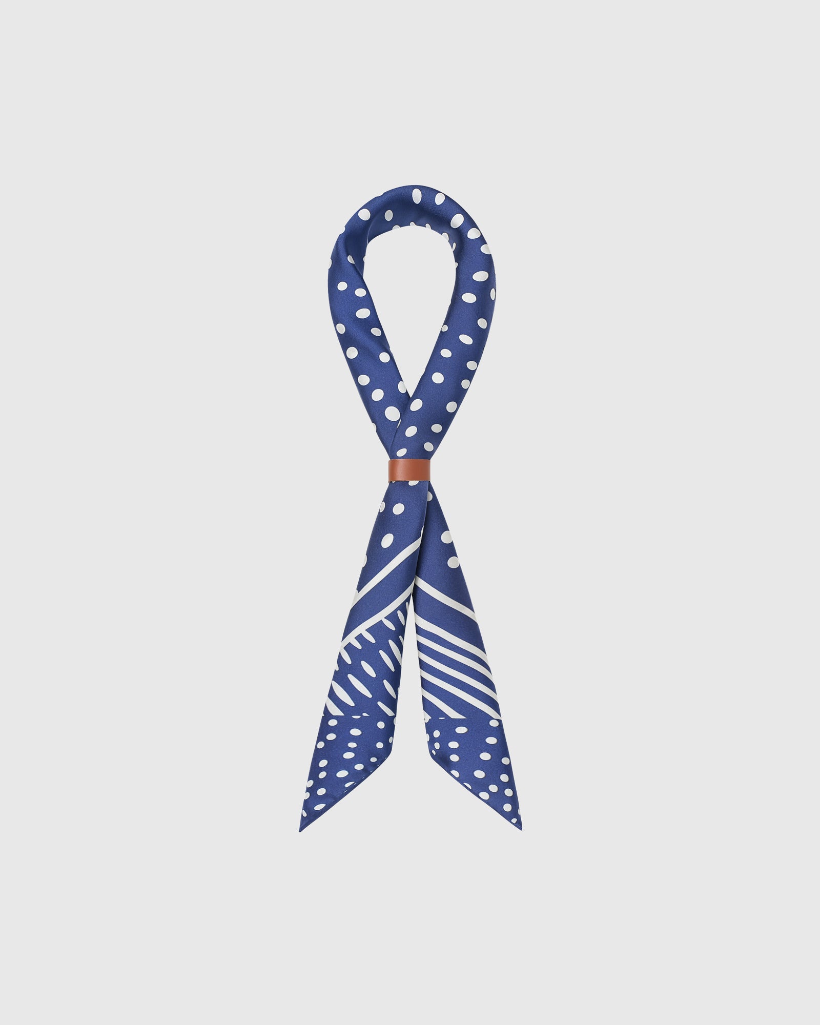 STICKYZOO stardust silk scarf looped through a leather cuff showing the larger polka-dot border