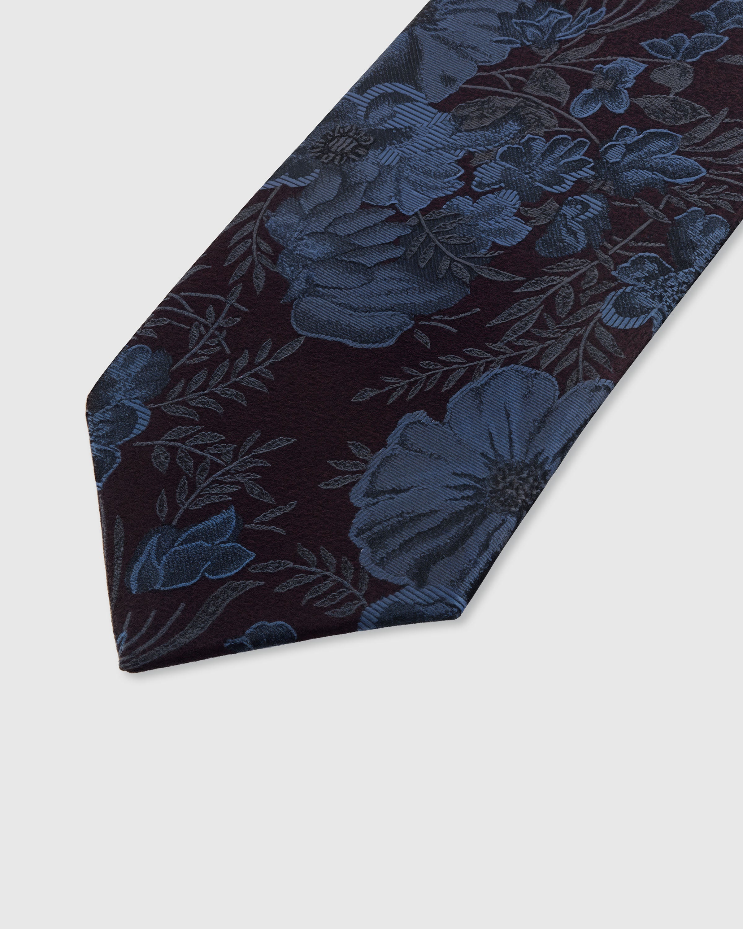 STICKYZOO PLUM PEONY TIE — hand-embroidered detail showing steel-blue peony blooms and delicate foliage, stitched not printed