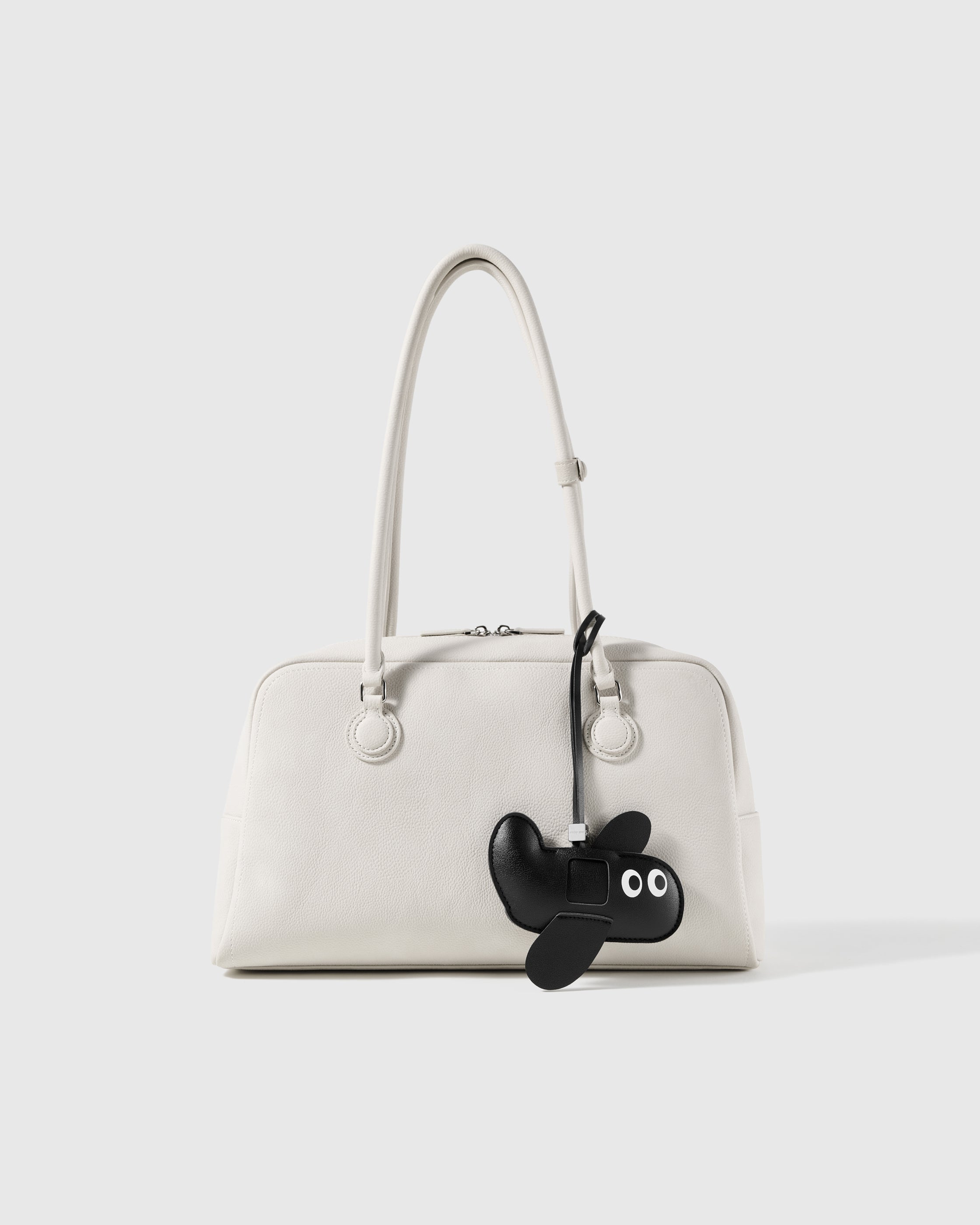 STICKYZOO black leather puppy charm styled on a handbag, a clean detail people notice