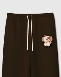 Close-up of plush puppy applique on dark brown cotton fleece showing sherpa texture, red beret, and embroidered eyes