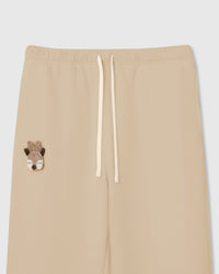 Close-up of plush reindeer face with felt antlers on cream cotton sweatpant