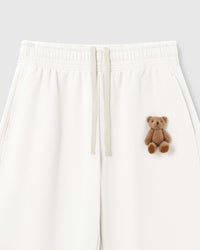 Close-up of hand-stitched 3D plush teddy bear on white 450gsm cotton fleece showing dimensional texture