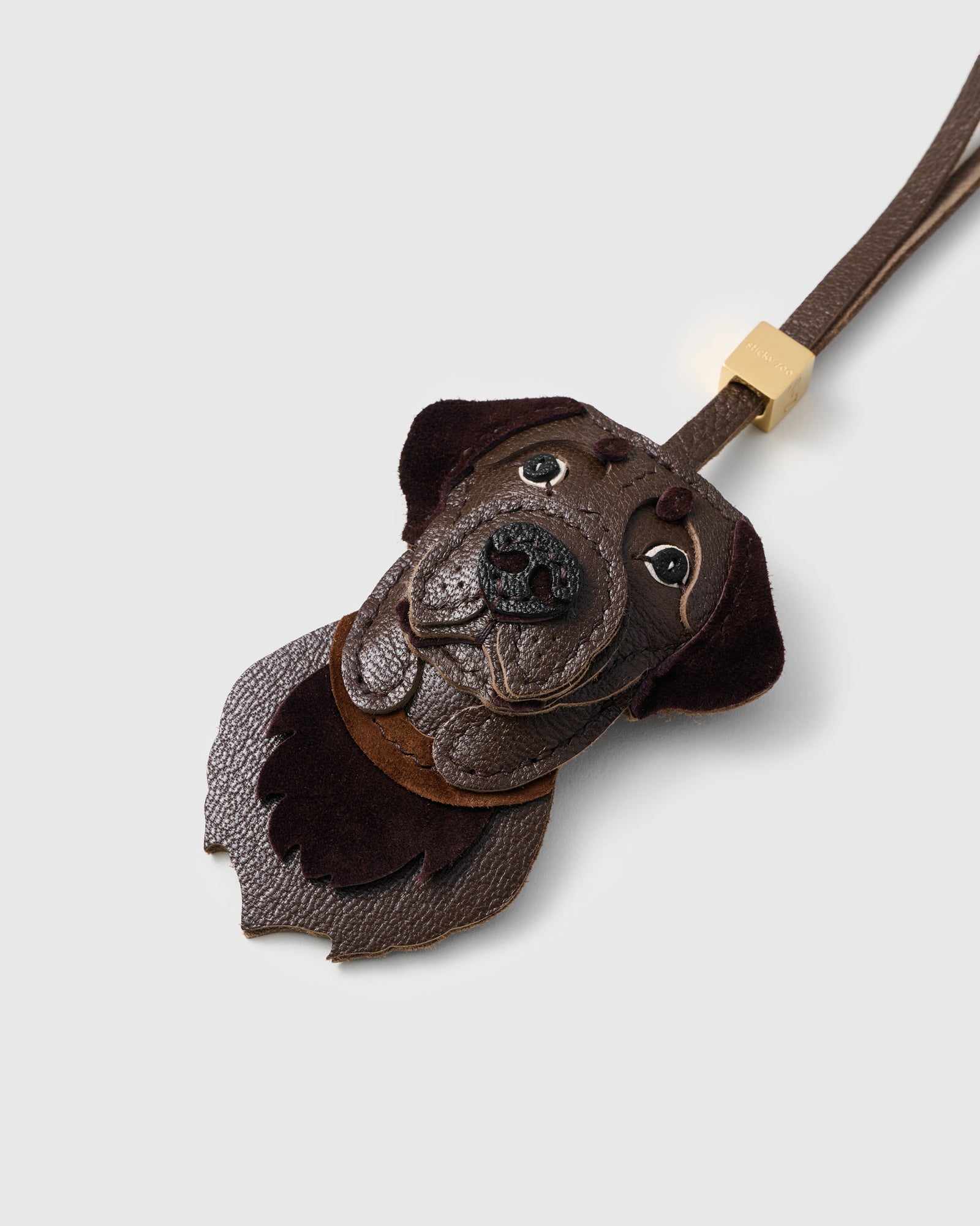 {{Dark leather collar.}} Detail — dark brown leather collar at the neck, layered muzzle, stitched brow dots. Every panel by hand.