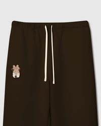 Close-up of plush reindeer and tartan acorn appliques on dark brown cotton sweatpant