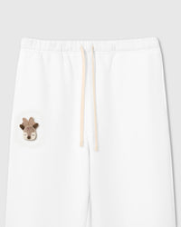 Close-up of plush reindeer with felt antlers and tartan acorn on white cotton sweatpant