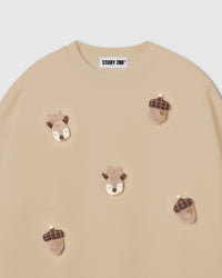 Close-up of hand-stitched plush reindeer face with felt antlers and embroidered features on cream cotton