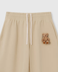 Close-up of hand-stitched plush teddy bear on cream 450gsm cotton fleece showing dimensional texture