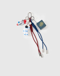 STICKYZOO Galactic Explorer Stack Charm flat lay featuring white astronaut figure, silver rocket with red and blue fins, 3D astronaut pop-up book, and red and navy hand-braided paracord ropes with stainless steel metal tips