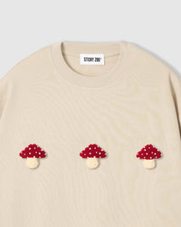 Detail of hand-stitched mushroom showing polka-dot cap pattern and dimensional plush construction