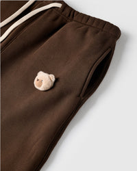 Detail of plush bear face with checkered ears on STICKYZOO brown sweatpant showing handmade texture