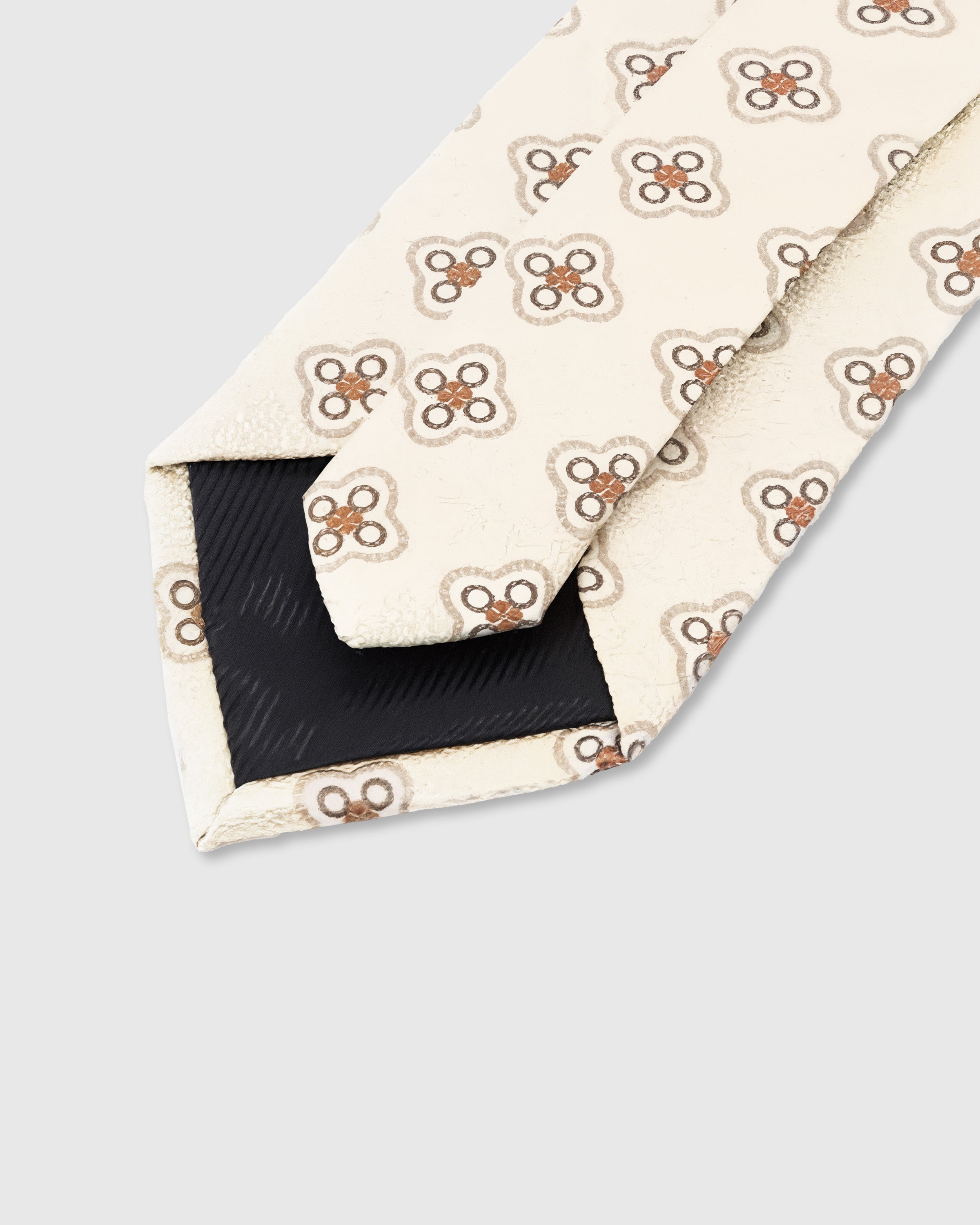 STICKYZOO Ivory Medallion Tie construction detail showing 45° bias-cut Italian method and structured interlining, rated 4.9 stars