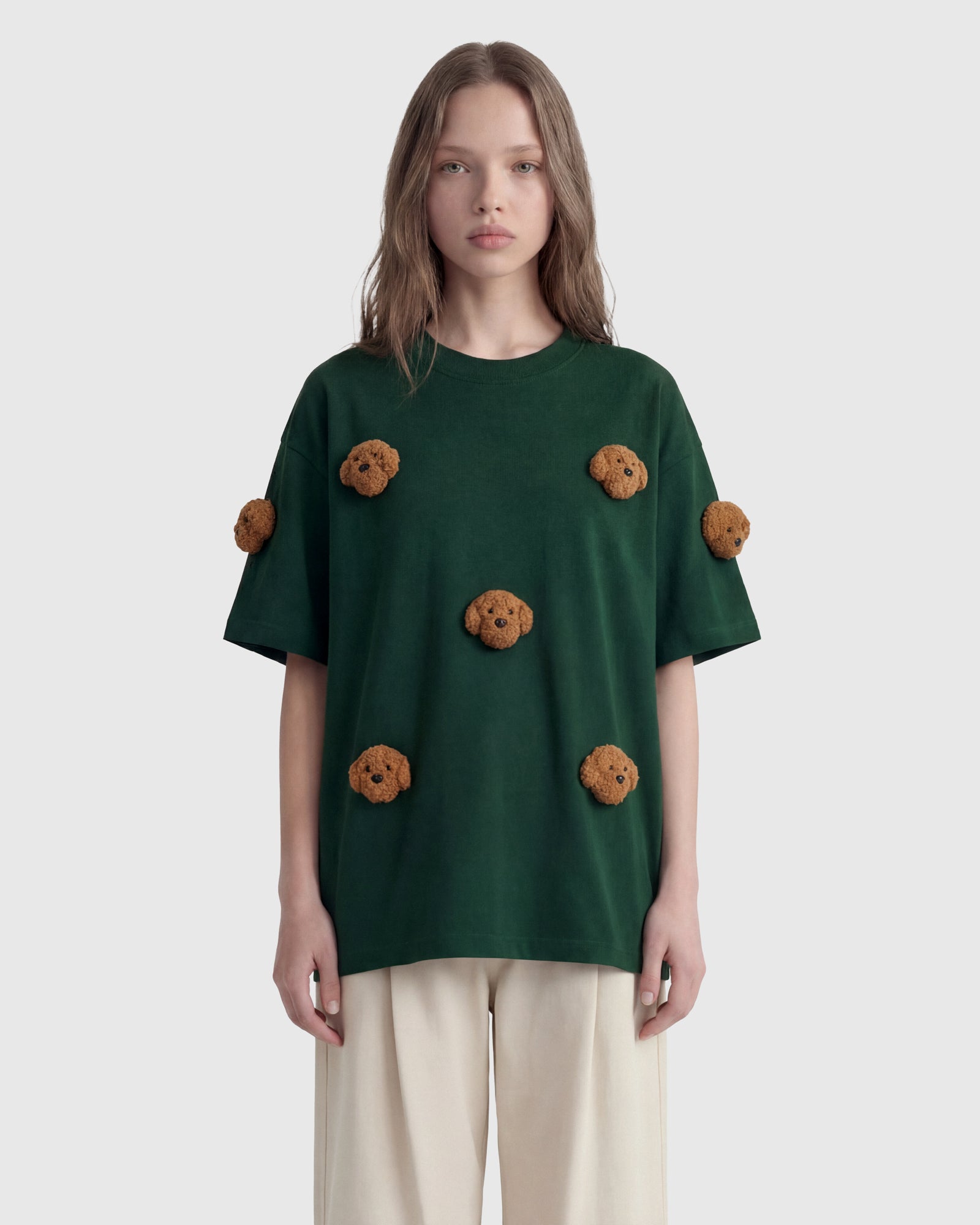 Model in green Poodle Parade T-Shirt front view showing all seven plush poodle appliques