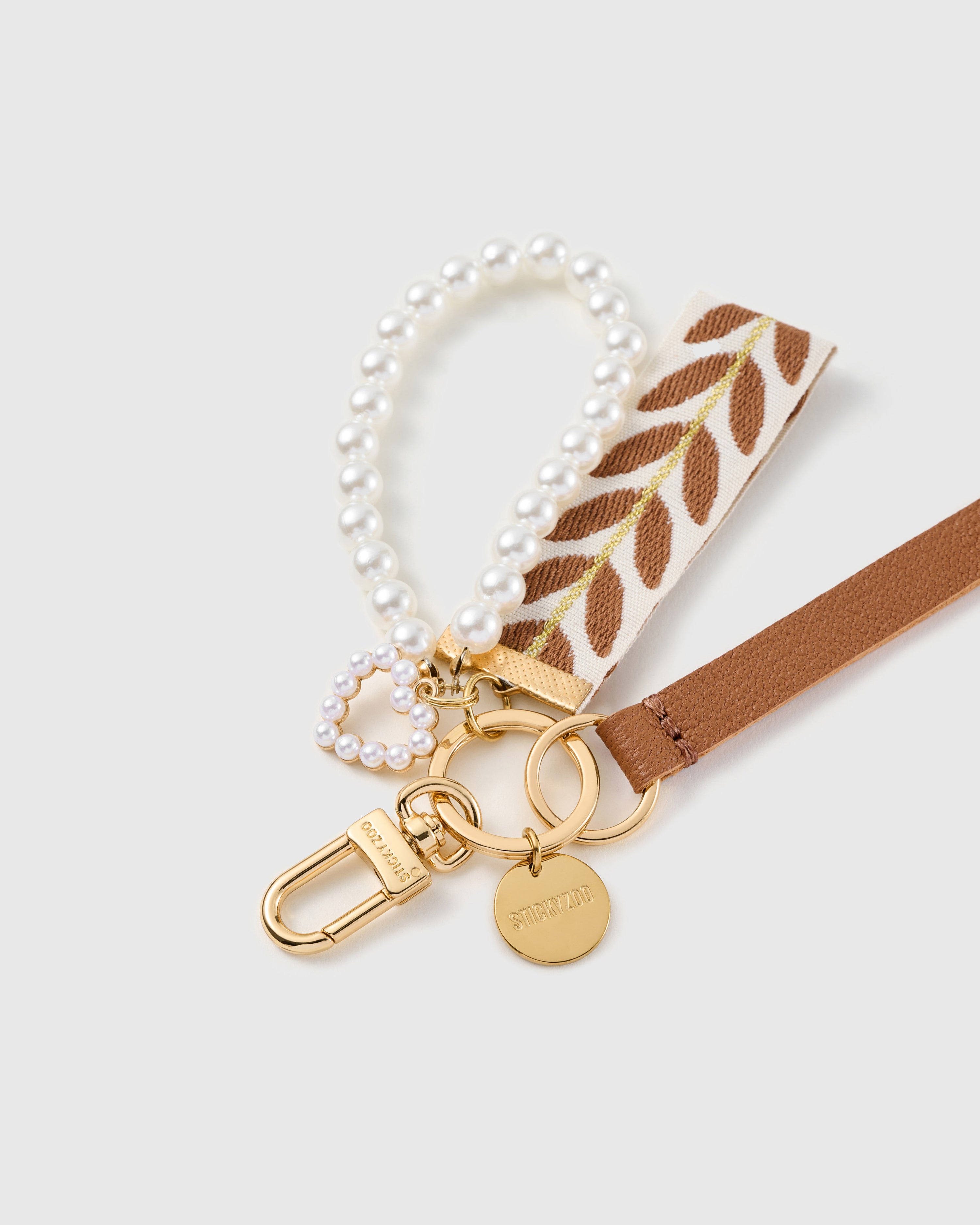 Pearl vine leather phone strap clipped to a phone case showing the hands-free wrist loop in use