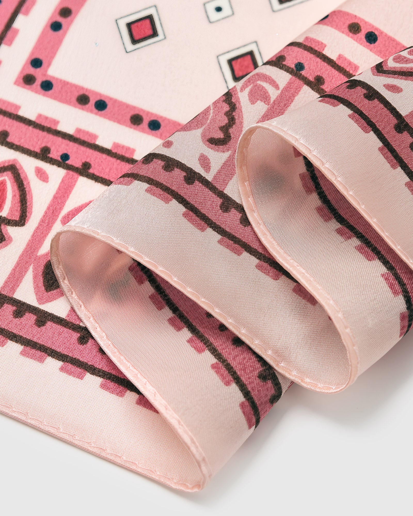 Close-up of the hand-illustrated tile border printed in archival inks on blush-pink silk