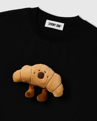 Detail of hand-stitched croissant applique on STICKYZOO black t-shirt showing dimensional craft
