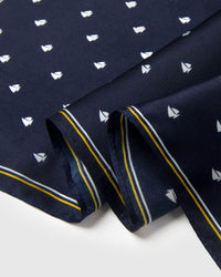 Close-up of the navy silk edge showing the mustard yellow stripe and small sailboat motif printed in archival ink