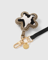 Close-up of the cow-print calf-hair star, hand whip-stitched olive edge and STICKYZOO gold disc
