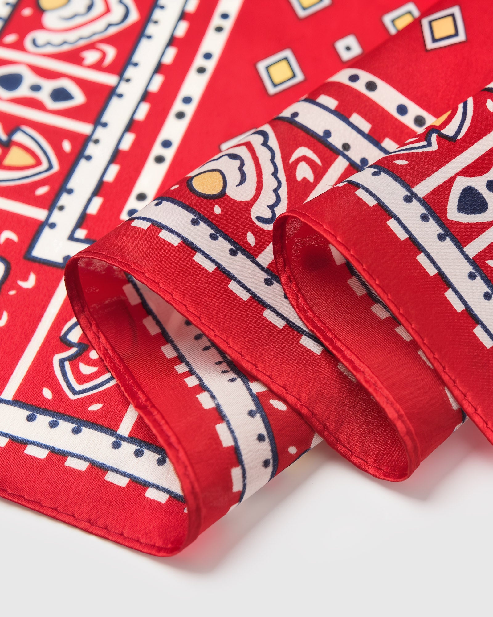 Close-up of the hand-illustrated tile border printed in archival inks on poppy-red silk