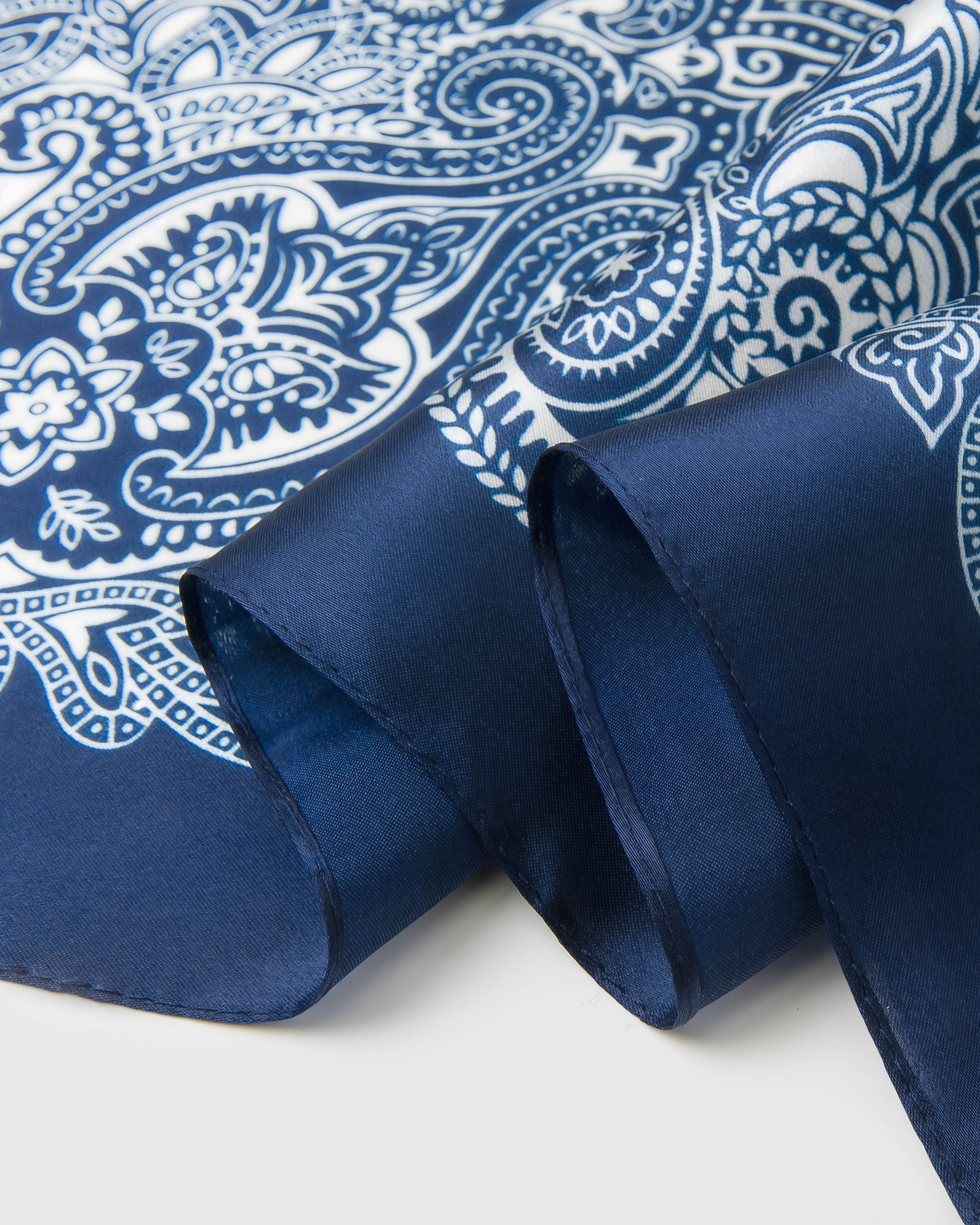 Close-up of the bandana paisley print and silk edge showing the archival ink detail on indigo silk
