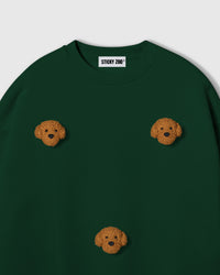 Close-up of plush poodle face on forest green cotton showing golden curly texture and embroidered detail