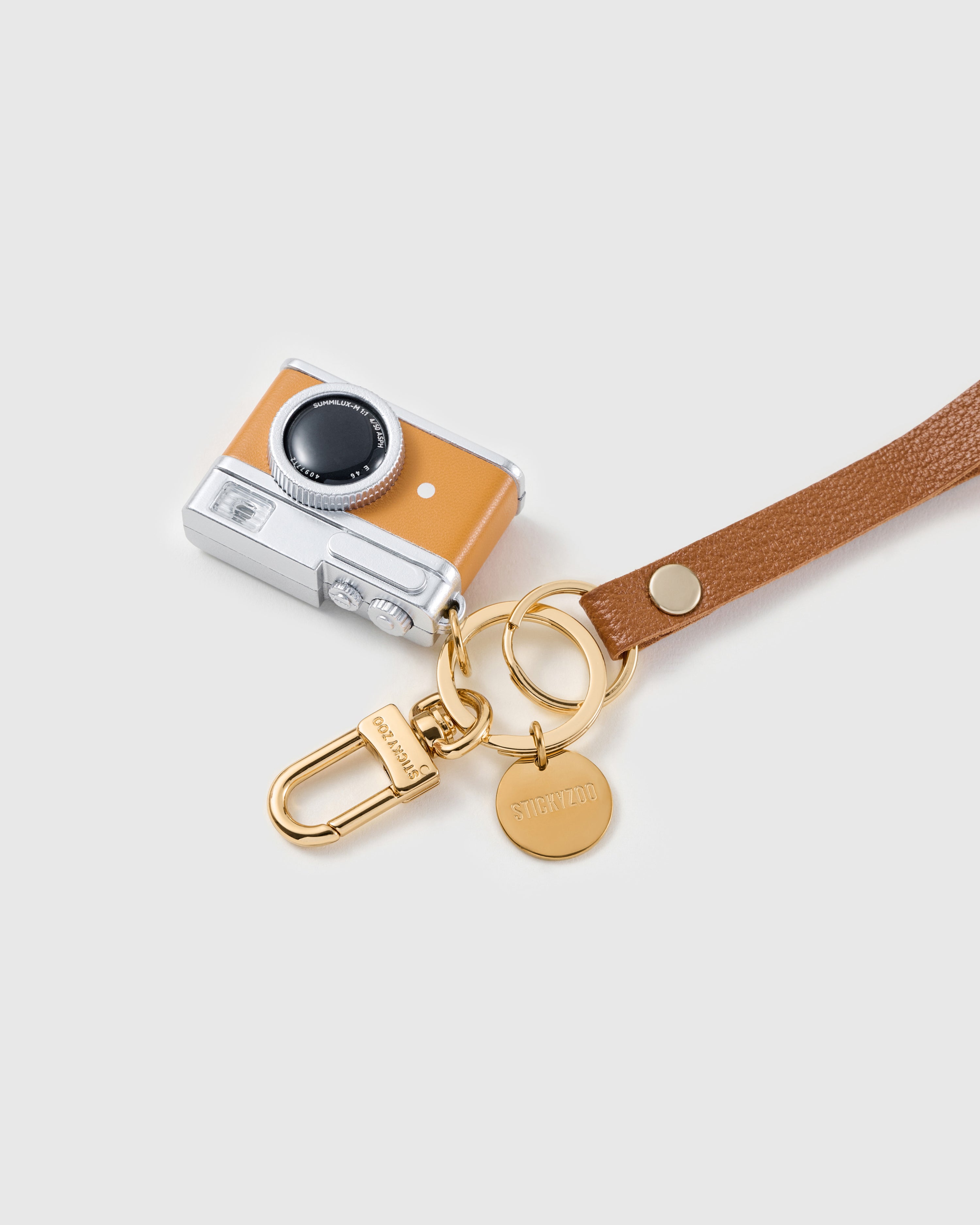 Tangerine lens leather phone strap clipped to a phone case showing the hands-free wrist loop in use