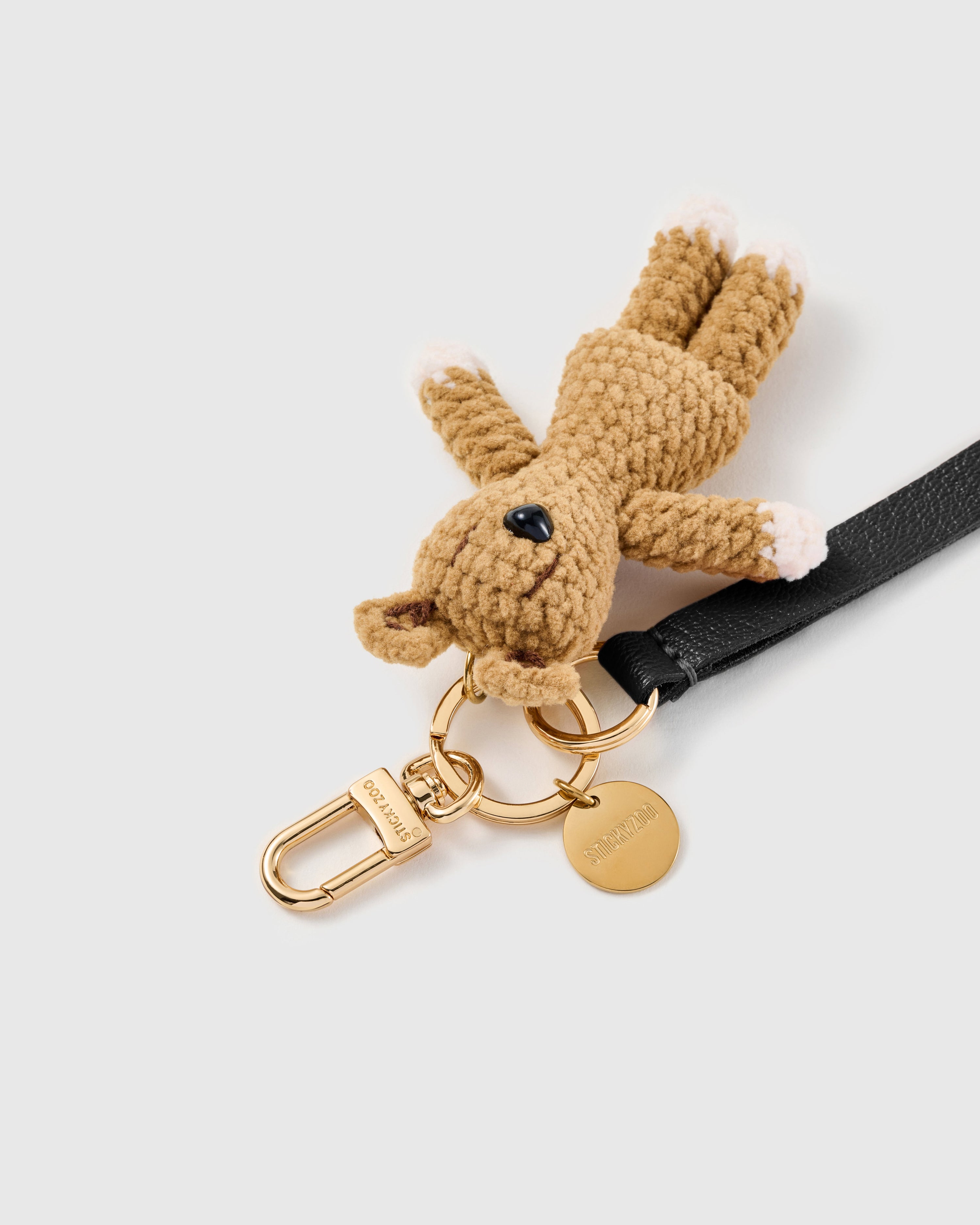 Noir bunny leather phone strap clipped to a phone case showing the hands-free wrist loop in use