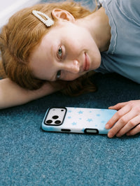 STICKYZOO sky-star phone case resting on carpet, its slim star-print shell facing up in soft daylight