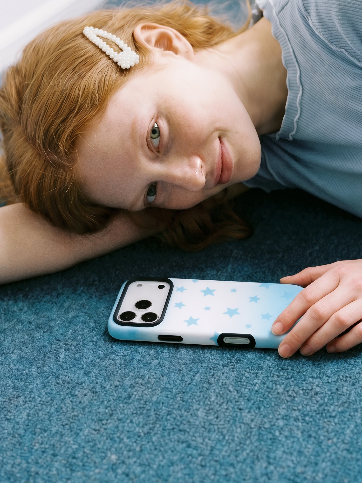 STICKYZOO sky-star phone case resting on carpet, its slim star-print shell facing up in soft daylight