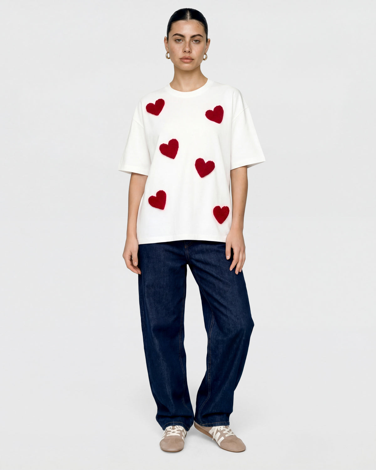 {{Pairs with everything}} Detail of multiple plush heart appliques scattered across white cotton showing varied placement