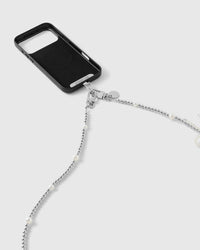 Silver-tone dual clasp and engraved disc joining the beaded strand to a black phone case, faux-pearls spaced along the beads.