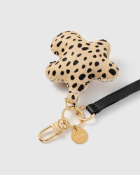 Cheetah flower leather phone strap close-up — calf-hair charm, hand whip-stitched edge, STICKYZOO engraved hook