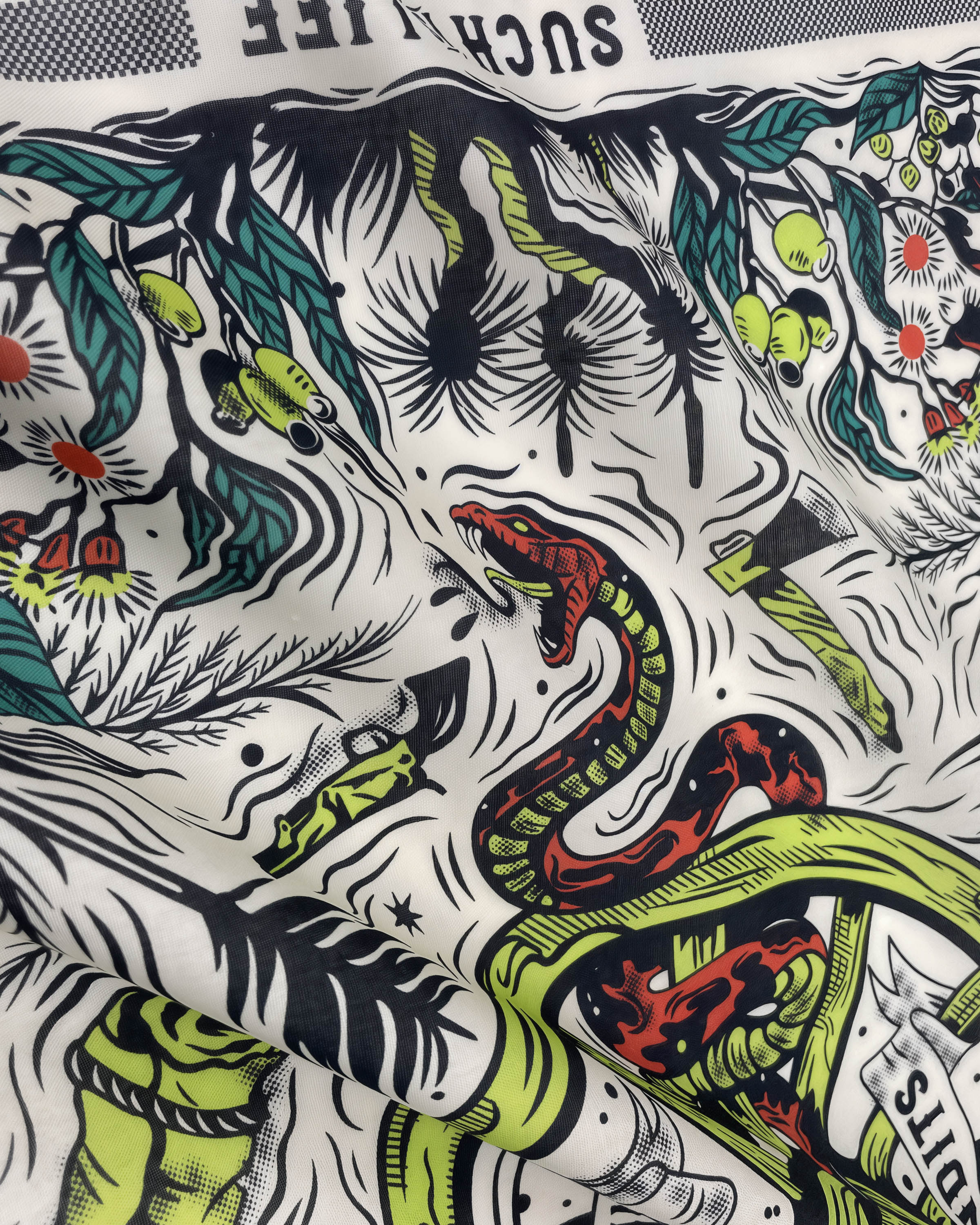 Detail of the printed serpent in chartreuse and red on the STICKYZOO serpent thicket silk scarf
```