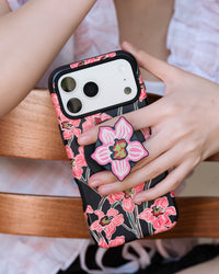 STICKYZOO midnight orchid phone case held in hand with the retractable MagSafe grip extended