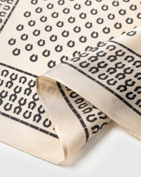 Close-up of the hand-illustrated horseshoe motif in charcoal archival ink on pure silk