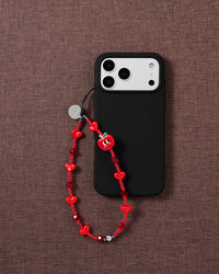 Red apple and heart bead phone strap worn hands-free from the wrist