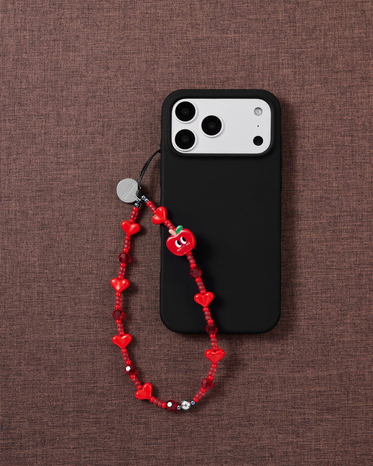 Red apple and heart bead phone strap worn hands-free from the wrist