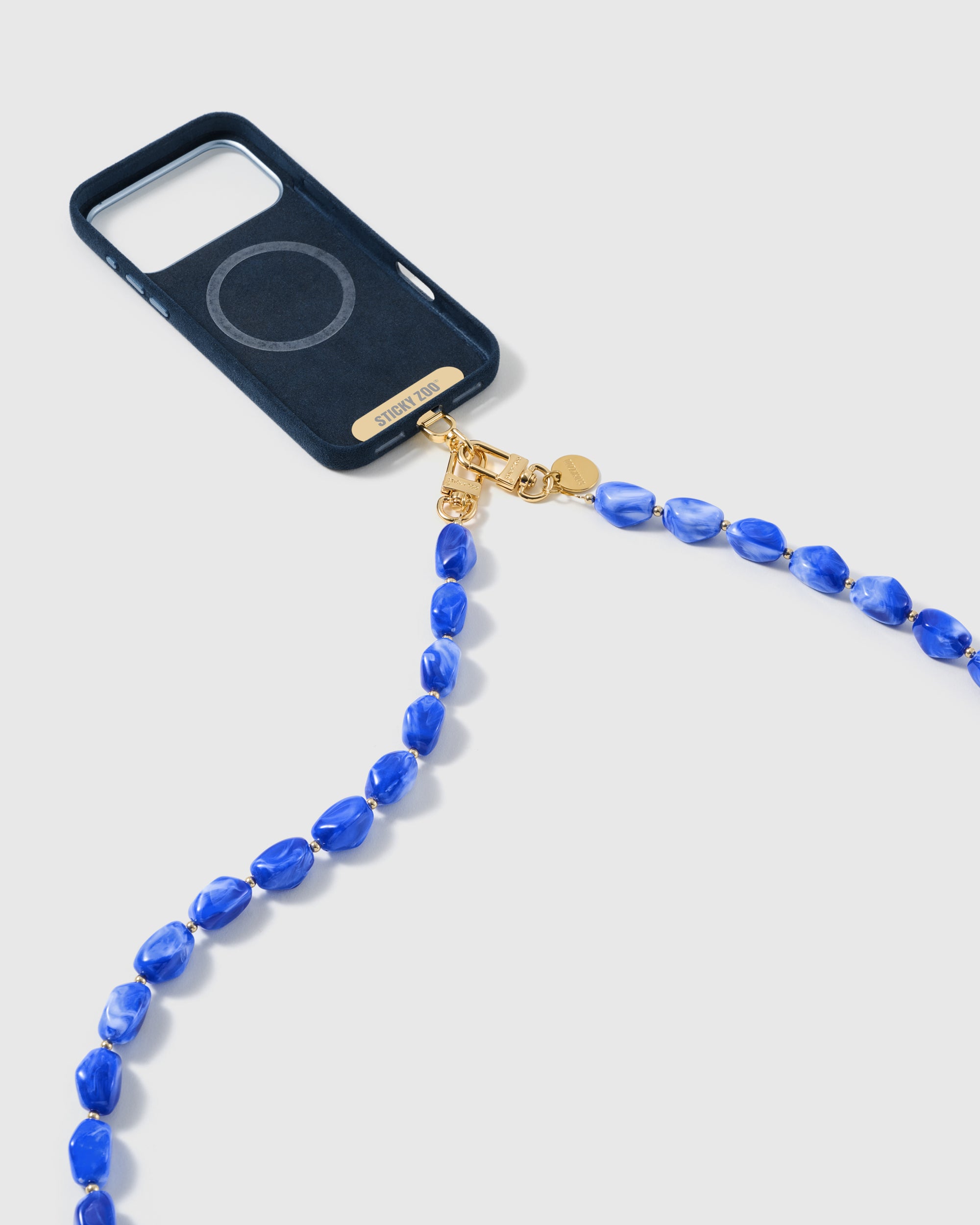 Cobalt-blue beaded cross-body strap clasped to a phone case by its dual gold-plated hooks
